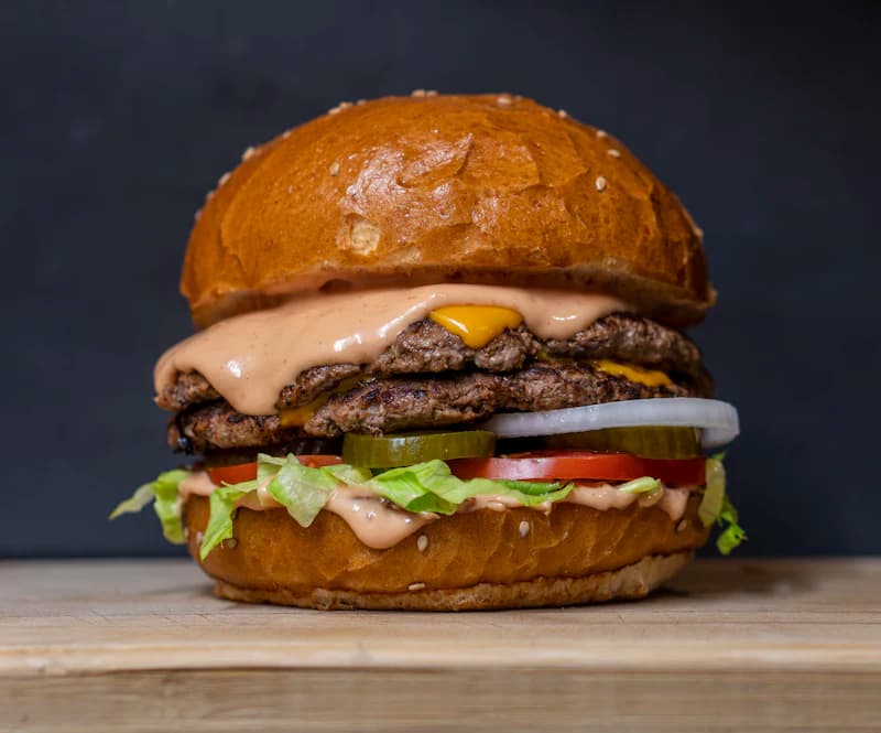 Hambúrguer com fritas sobre uma mesa de madeira